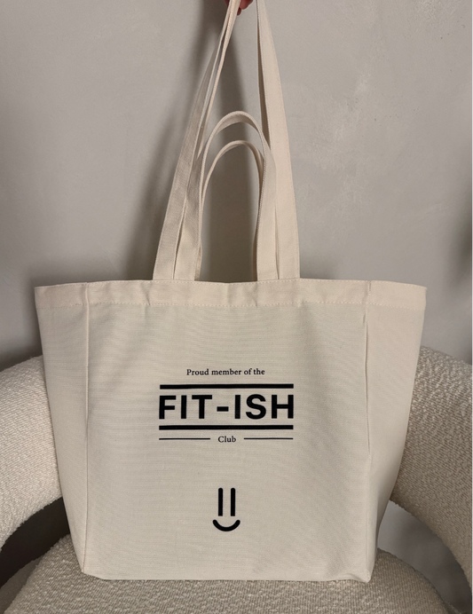 Canvas tote bag with double handle and 'Proud member of the FIT-ISH Club' text on a neutral background
