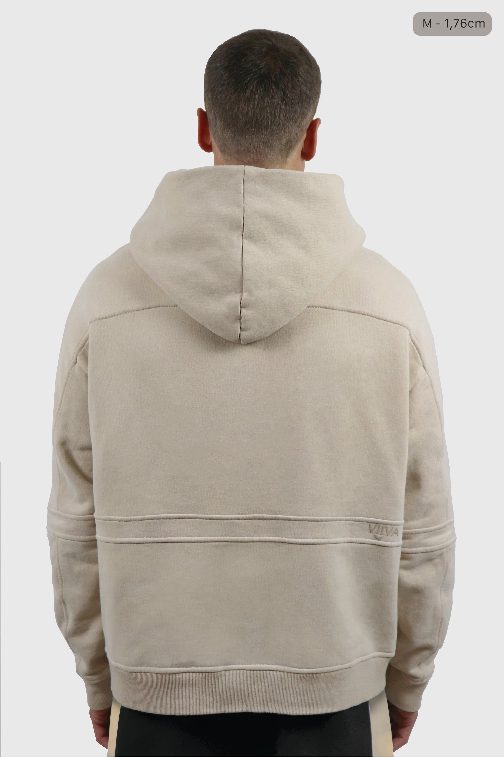 Man wearing a beige cotton hoodie on a white background