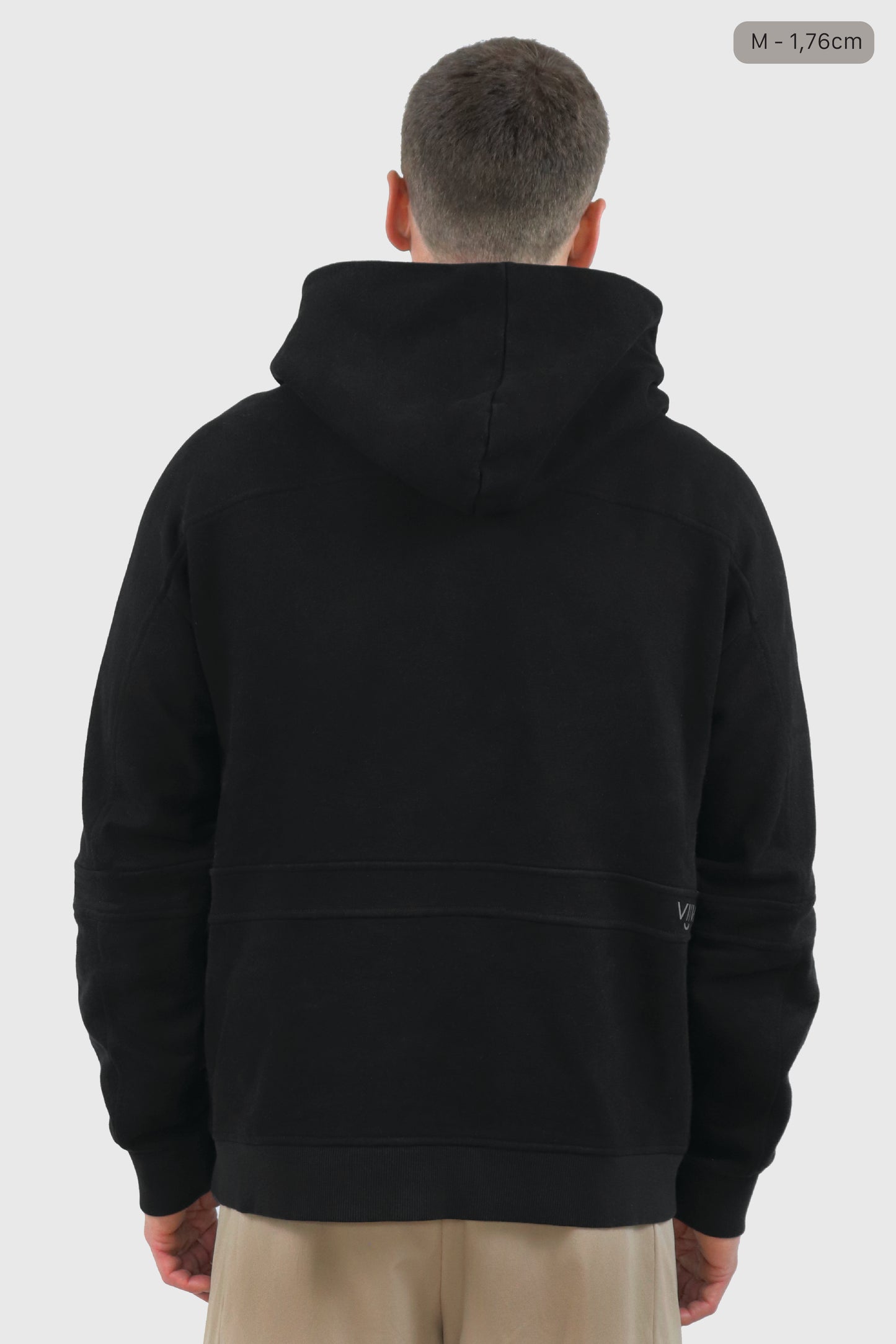 Man wearing a black cotton hoodie and beige shorts