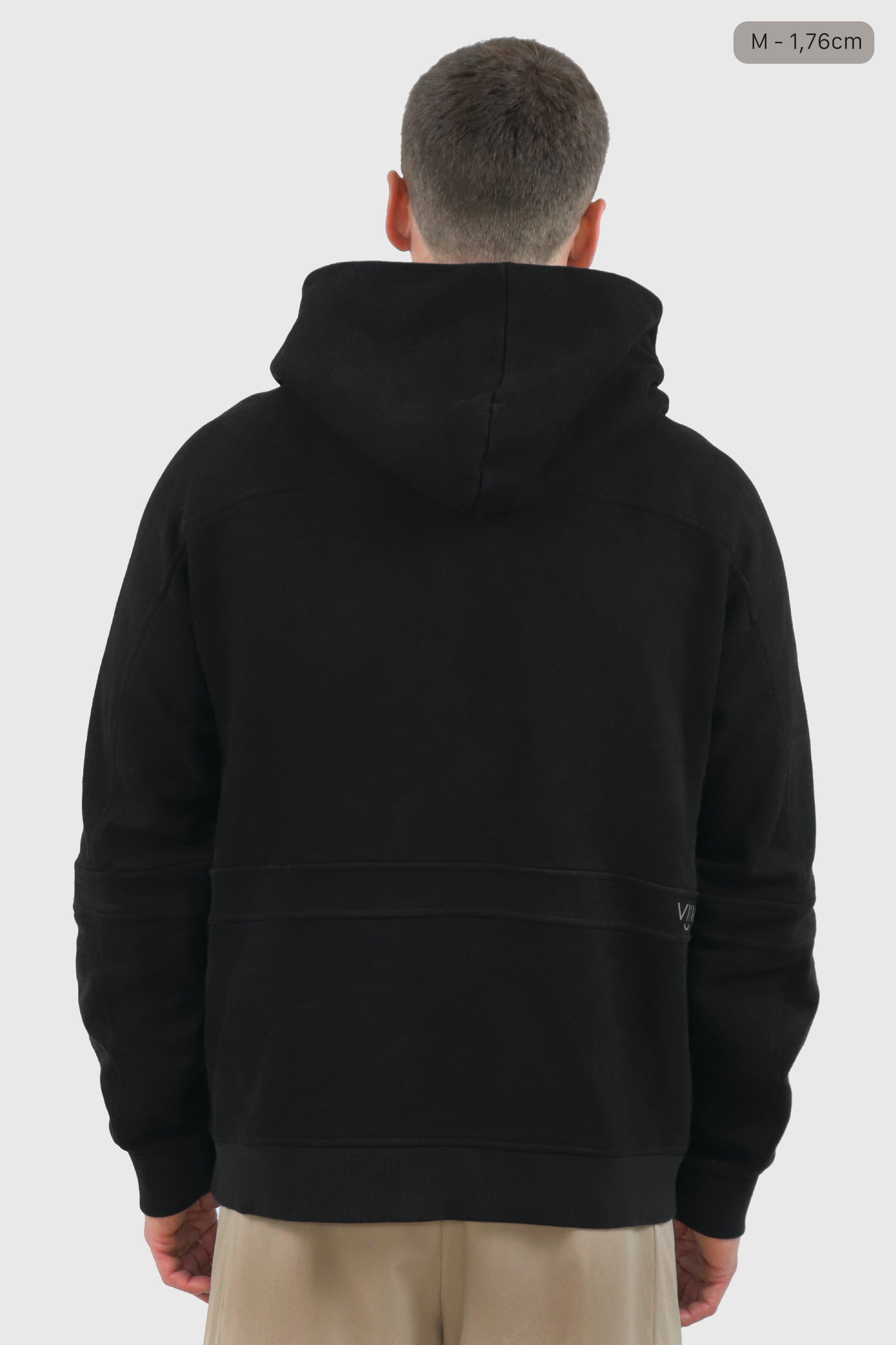 Man wearing a black cotton hoodie and beige shorts