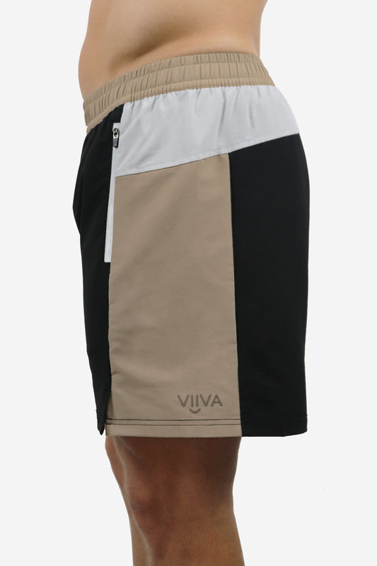 Color-blocked men's shorts with black, beige, and white sections, zipper pockets, small logo print, on a white background