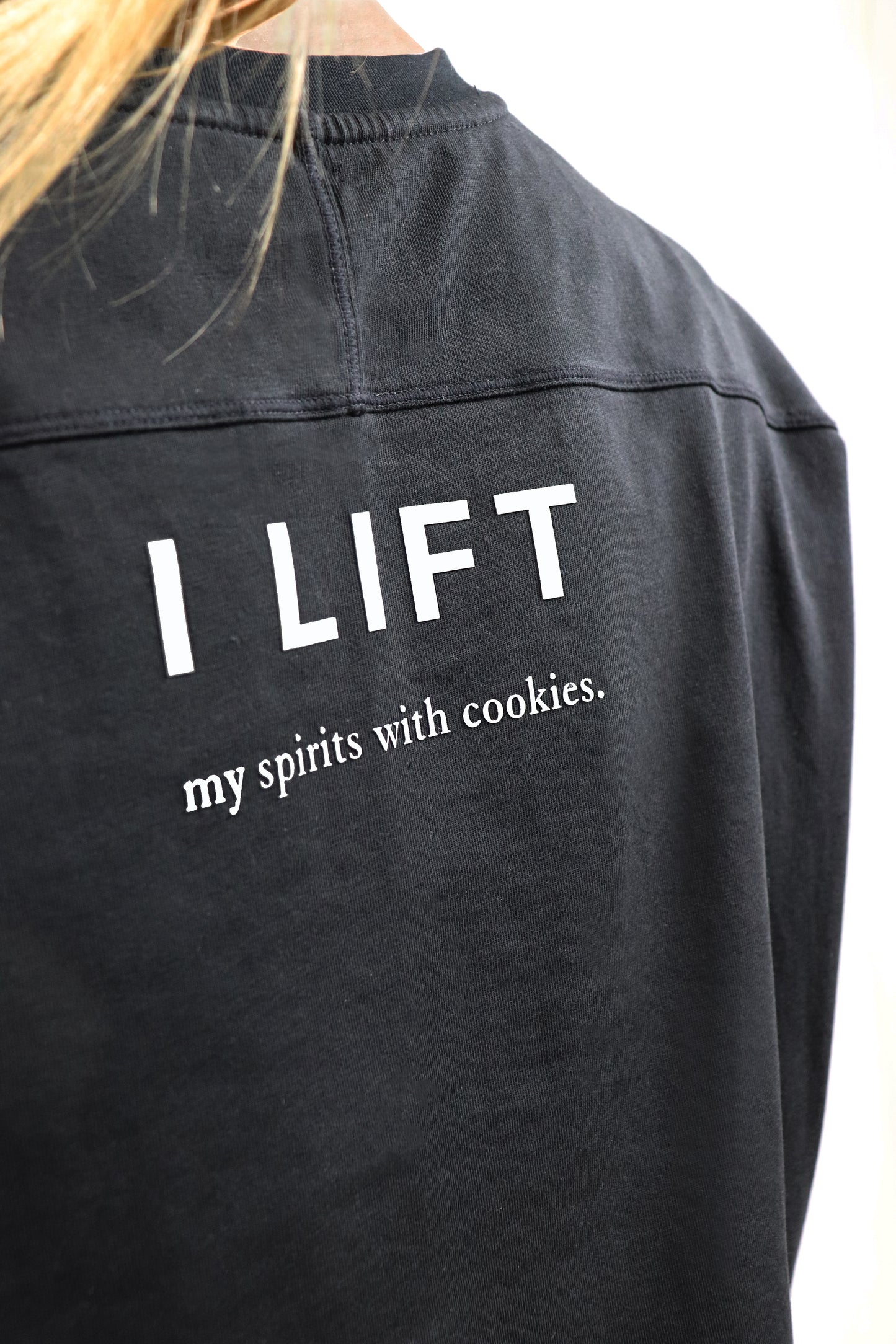 Black cotton t-shirt with cuts with text 'I LIFT my spirits with cookies' on a white background