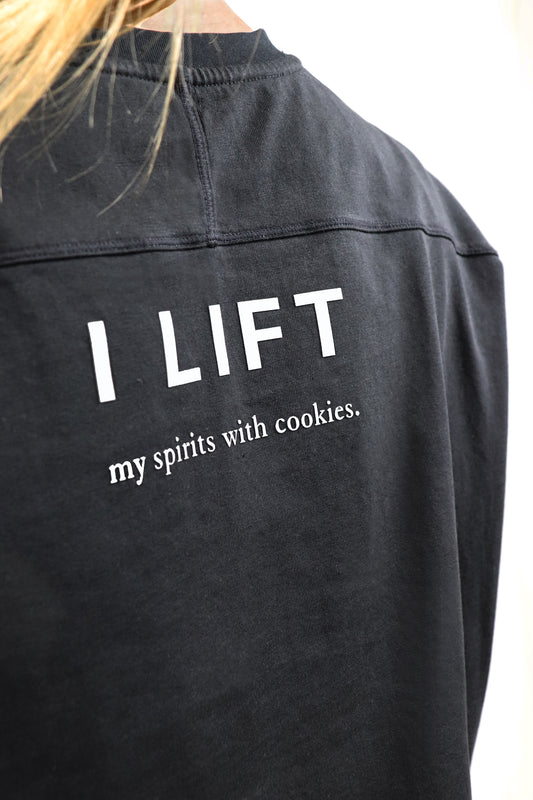 Black cotton t-shirt with cuts with text 'I LIFT my spirits with cookies' on a white background