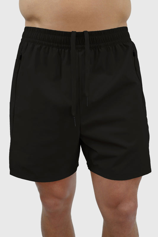 Black men's shorts with elastic waistband, drawstrings and zipper pockets worn by a person on a white background