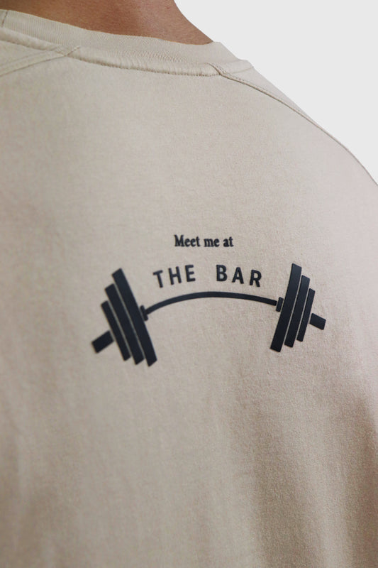 Beige t-shirt with 'Meet me at the bar' phrase with barbell graphic  printed on the back