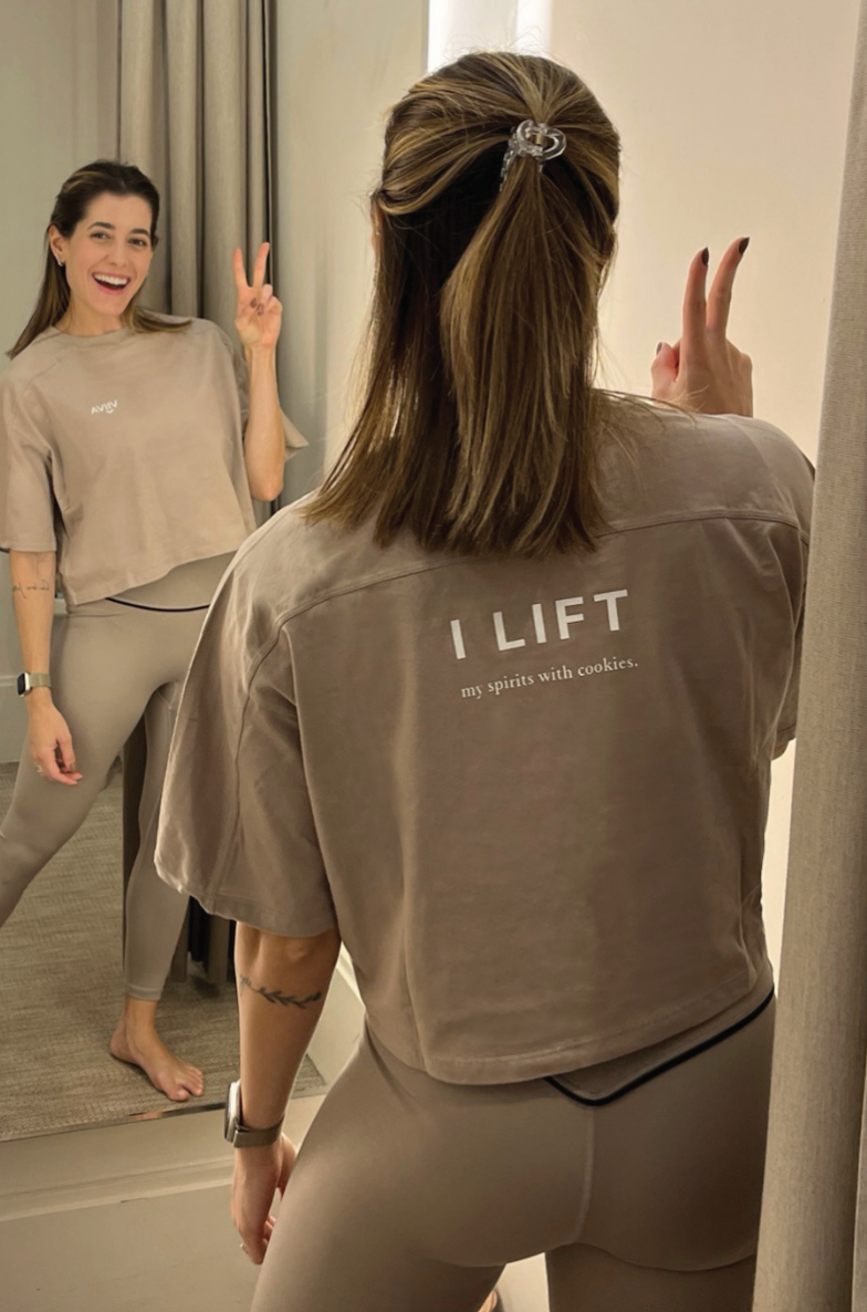 Kvinna i beige bomulls-t-shirt med tryck i vitt 